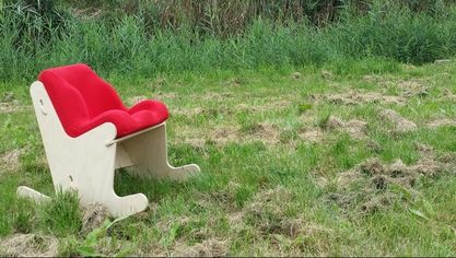Kleine schommelstoel met de zitorthese die op maat voor jou wordt gemaakt. Schommelstoel staat in het gras. Een Hollands plaatje. 