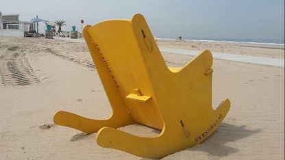 Houten schommelstoel op het strand. Met zicht op zee. Een foto met beleving, schommelstoel helpt tegen rugpijn, slapeloosheid en evenwichtsstoornis. 